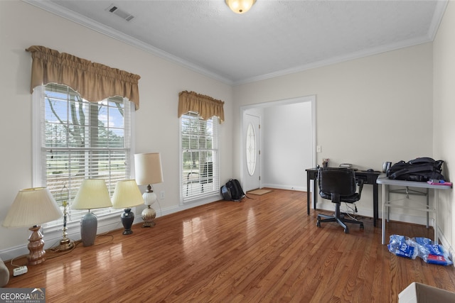 office area with crown molding, wood finished floors, and visible vents