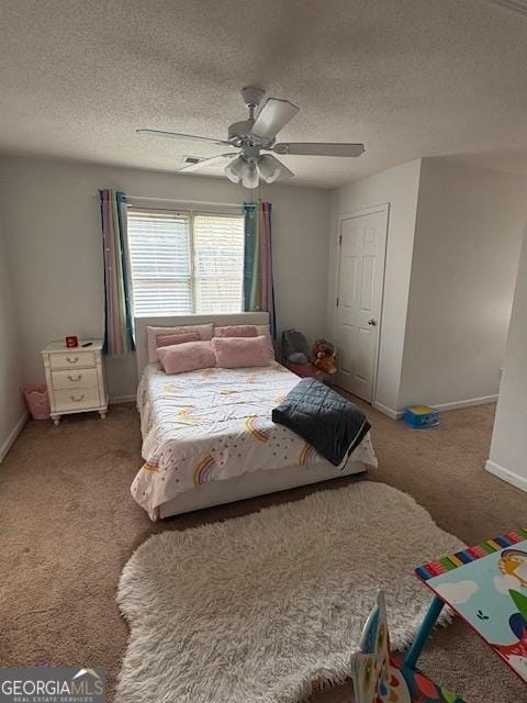 carpeted bedroom featuring ceiling fan and a textured ceiling