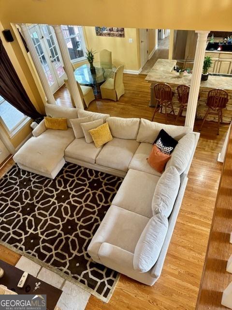 living room featuring ornate columns and hardwood / wood-style floors