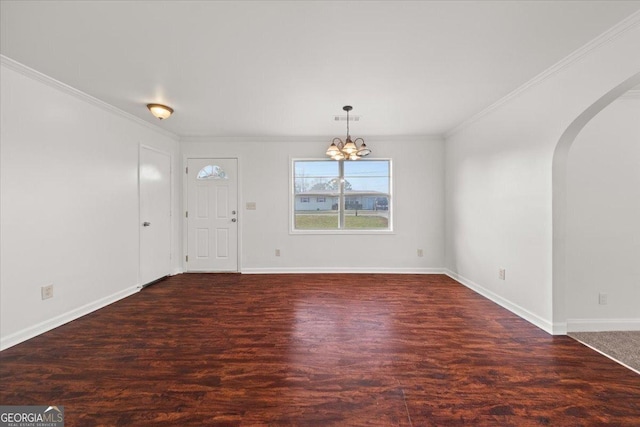 entrance foyer with dark hardwood / wood-style flooring, crown molding, and a chandelier