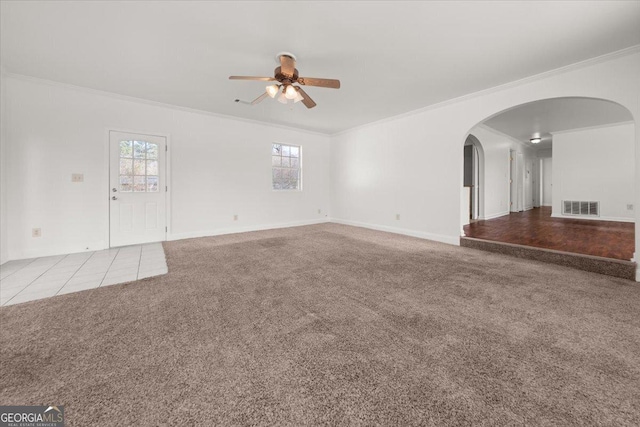 unfurnished living room with ceiling fan, ornamental molding, and light carpet