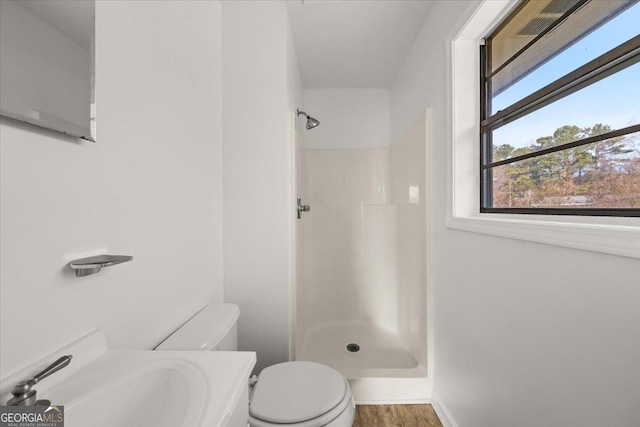 bathroom featuring walk in shower, toilet, sink, and hardwood / wood-style floors