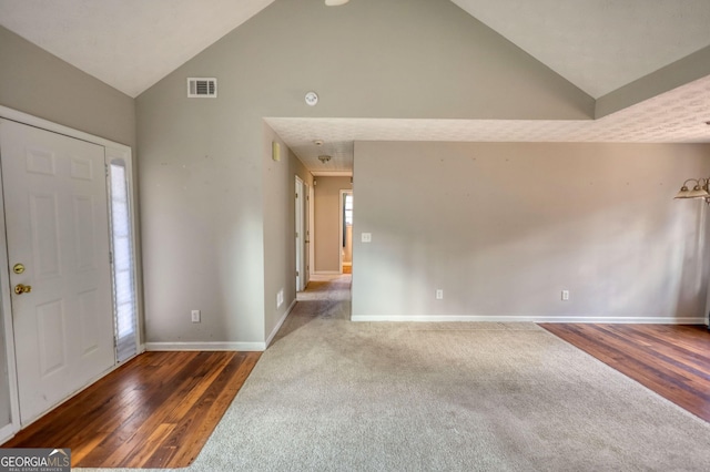 entryway featuring dark wood-type flooring and high vaulted ceiling