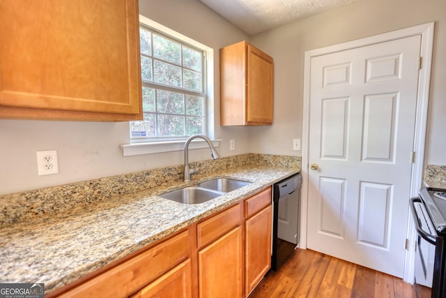 kitchen with hardwood / wood-style floors, dishwasher, sink, stainless steel range with electric cooktop, and light stone counters