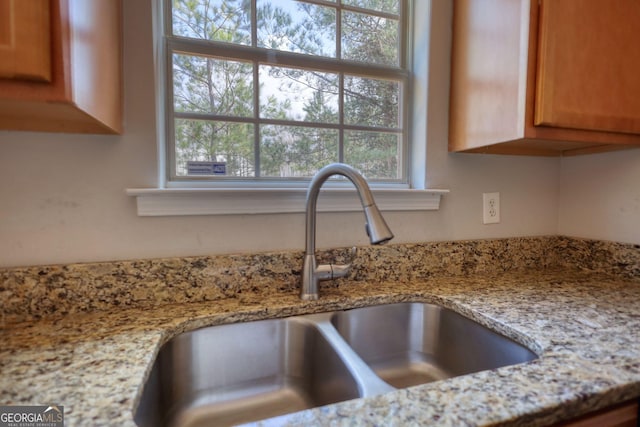 room details featuring sink and light stone counters