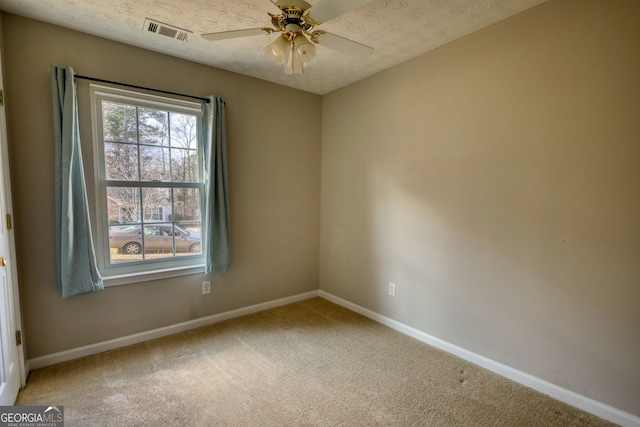 empty room with ceiling fan, carpet, and a textured ceiling