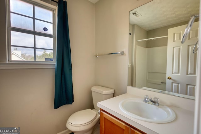 bathroom with vanity, toilet, and a shower