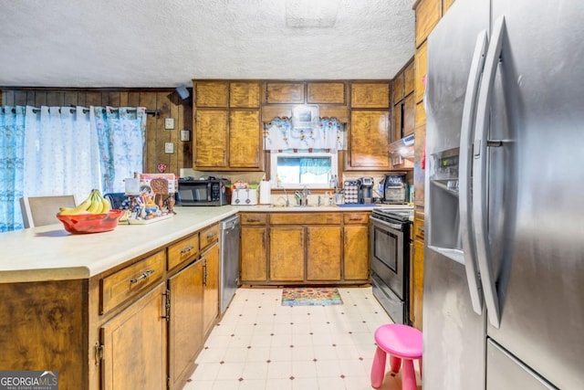 kitchen featuring stainless steel appliances, sink, and a textured ceiling