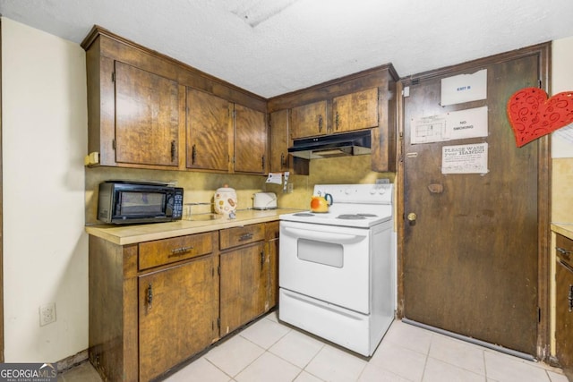 kitchen featuring white electric stove, light tile patterned floors, and a textured ceiling