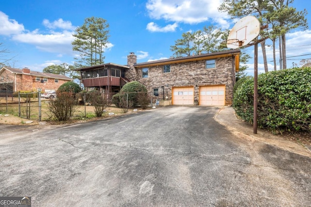 view of property featuring a garage and a sunroom