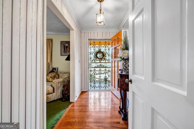 foyer entrance featuring ornamental molding and wood-type flooring