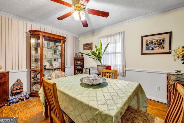 dining area featuring hardwood / wood-style flooring, crown molding, and a textured ceiling