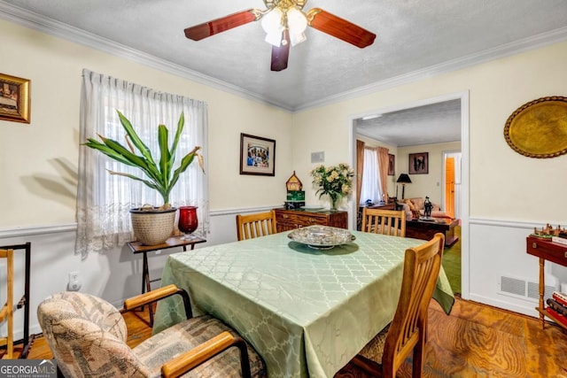 dining area with hardwood / wood-style floors, plenty of natural light, and ornamental molding