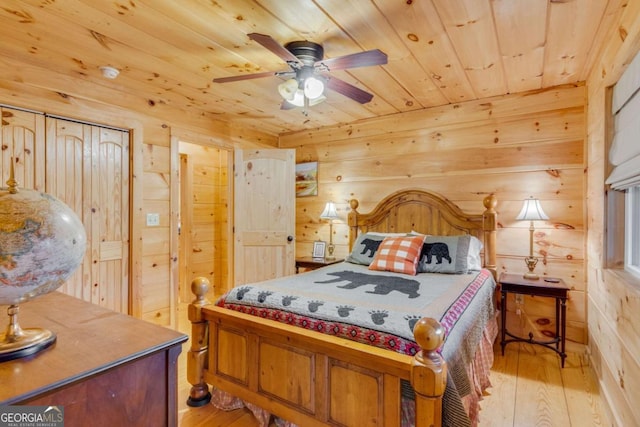 bedroom featuring light hardwood / wood-style flooring, wooden ceiling, and wood walls