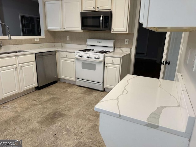 kitchen featuring white cabinetry, stainless steel appliances, sink, and decorative backsplash