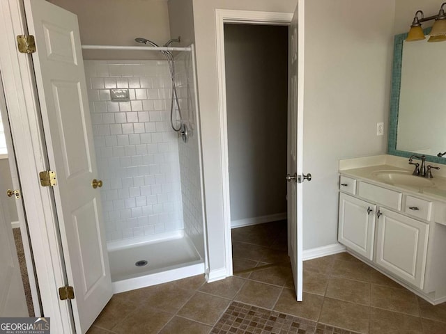 bathroom featuring tiled shower, vanity, and tile patterned flooring