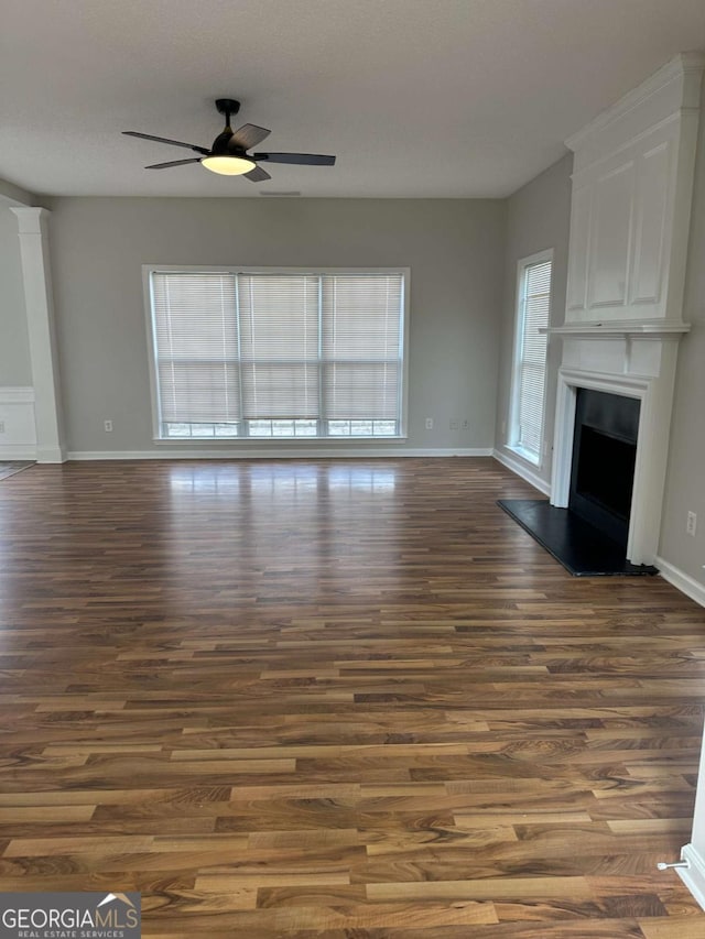 unfurnished living room featuring dark hardwood / wood-style floors and ceiling fan