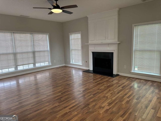 unfurnished living room featuring dark hardwood / wood-style flooring, a fireplace, and ceiling fan