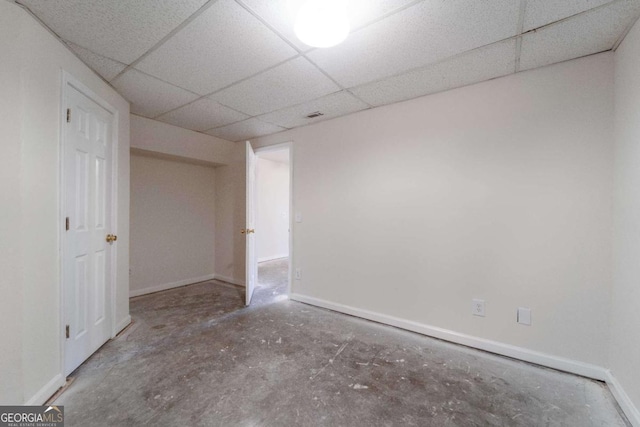 empty room with a drop ceiling and concrete floors