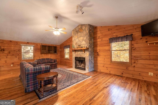 living room featuring lofted ceiling, hardwood / wood-style floors, and wooden walls