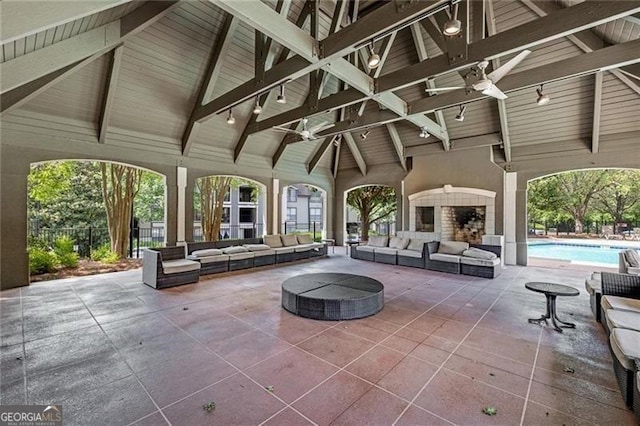 view of patio / terrace featuring a gazebo, ceiling fan, and an outdoor living space with a fireplace