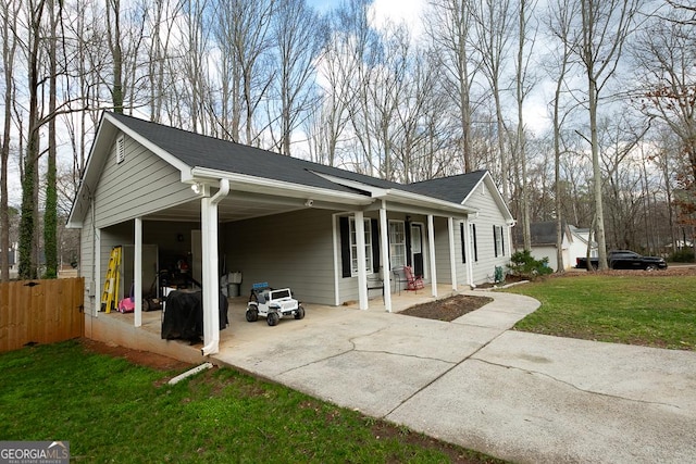 view of side of home featuring a yard, a carport, and covered porch