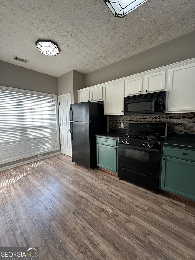 kitchen featuring white cabinetry, tasteful backsplash, black appliances, a textured ceiling, and light wood-type flooring