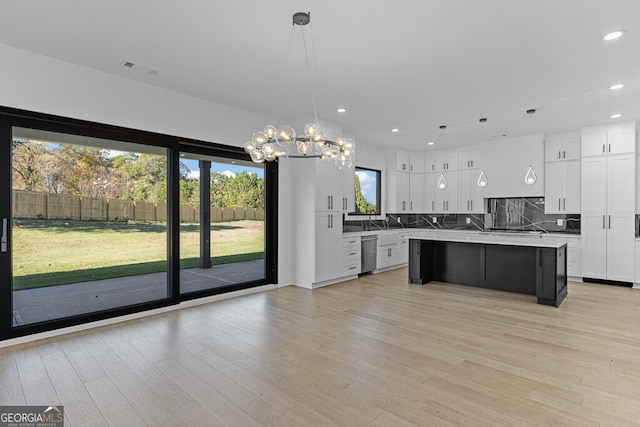 kitchen featuring white cabinetry, hanging light fixtures, tasteful backsplash, and a center island