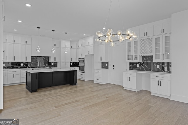 kitchen with pendant lighting, a center island, light hardwood / wood-style floors, and white cabinets