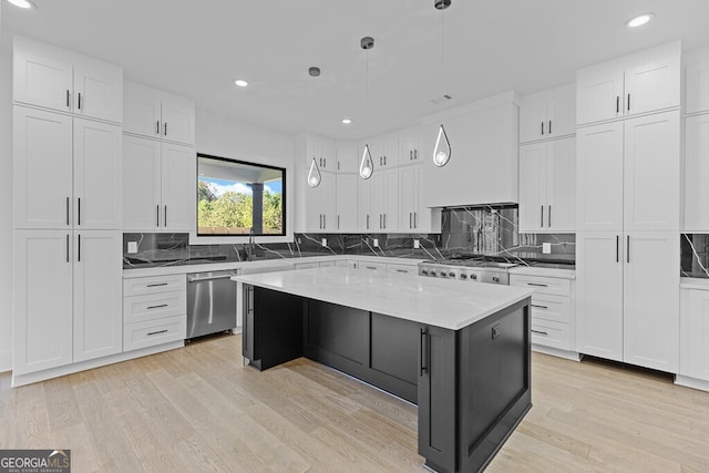 kitchen featuring stainless steel dishwasher, a kitchen island, pendant lighting, light stone countertops, and white cabinets