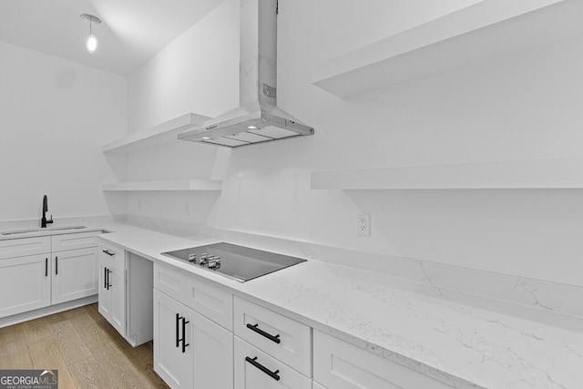 kitchen with sink, white cabinets, exhaust hood, light stone counters, and black electric cooktop