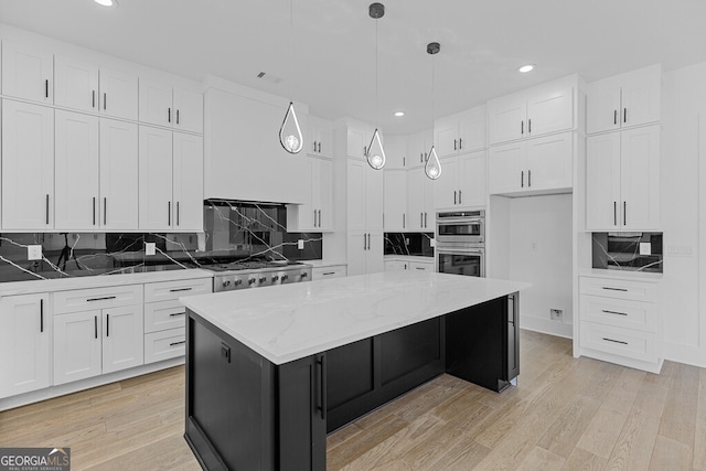 kitchen with white cabinetry, a center island, light wood-type flooring, pendant lighting, and stainless steel double oven