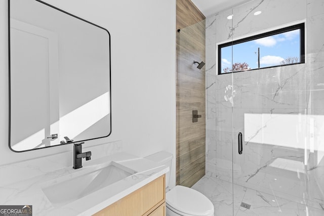 bathroom with a shower with door, vanity, and toilet