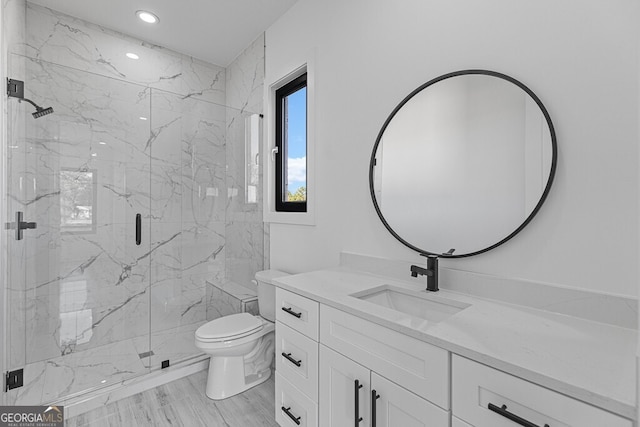 bathroom featuring vanity, toilet, and a shower with door