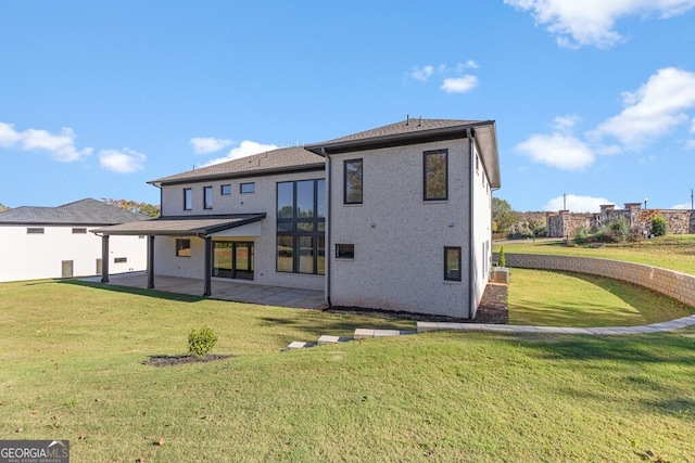 rear view of property featuring a patio area and a lawn