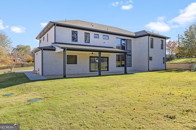 back of property featuring a patio and a yard