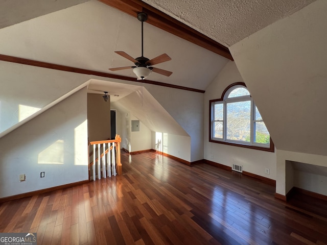 additional living space with lofted ceiling with beams, ceiling fan, dark wood-type flooring, and a textured ceiling