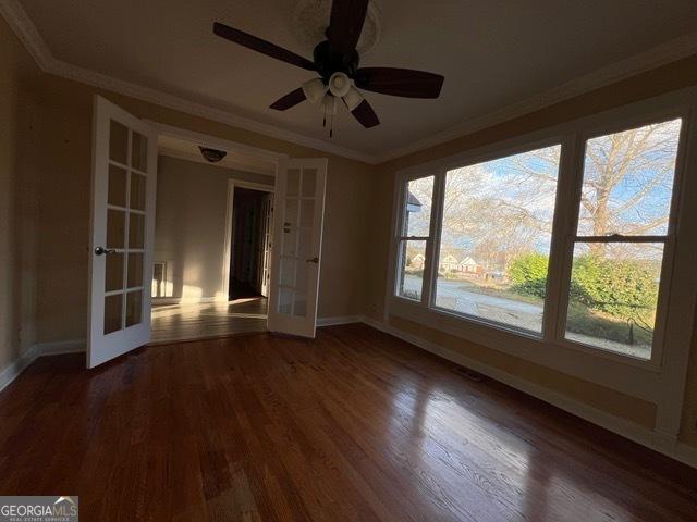 unfurnished room featuring french doors, ornamental molding, and dark hardwood / wood-style floors