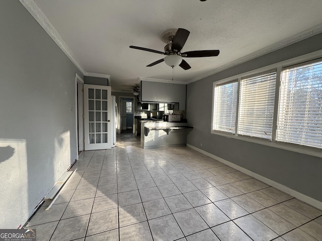 interior space featuring light tile patterned floors, ornamental molding, a textured ceiling, and ceiling fan