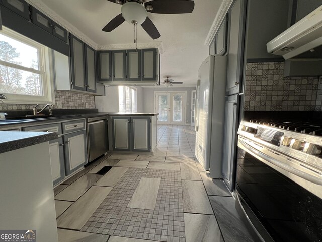 kitchen featuring appliances with stainless steel finishes, gray cabinetry, exhaust hood, and sink