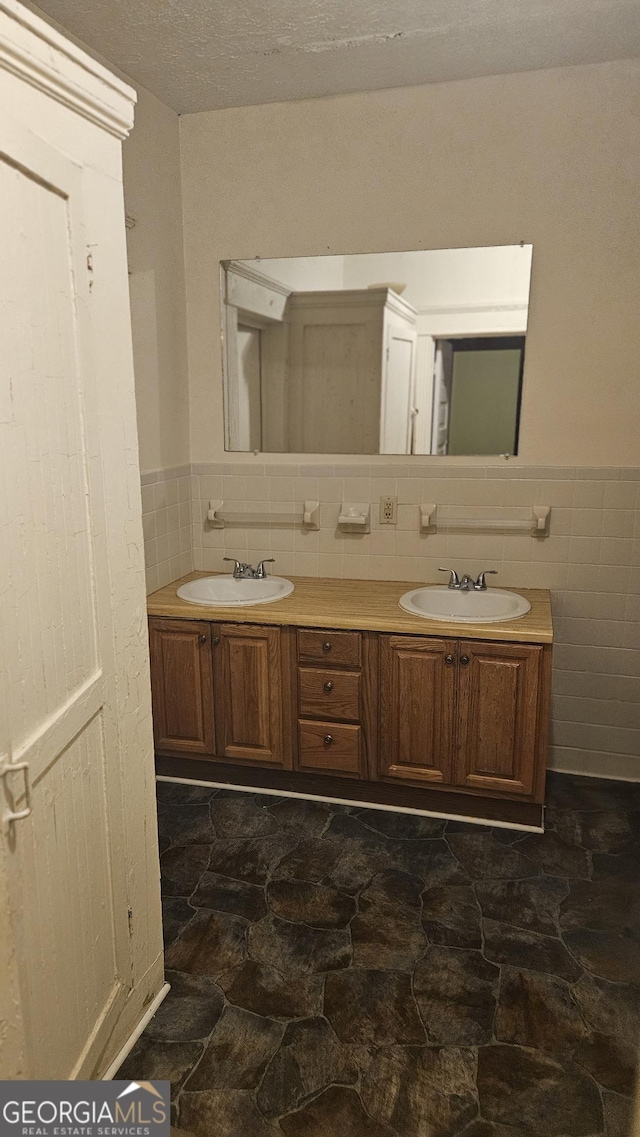 bathroom featuring vanity, tile walls, and a textured ceiling