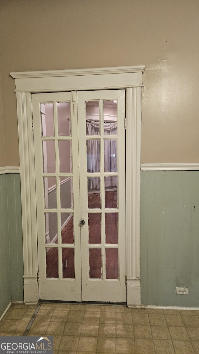 doorway with french doors and wood walls