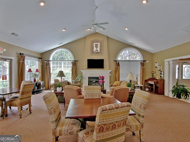 carpeted dining space featuring ornate columns, high vaulted ceiling, and ceiling fan