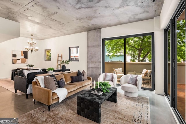 living room with an inviting chandelier and concrete floors