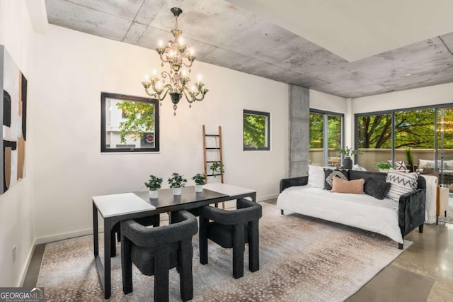 dining room featuring an inviting chandelier and concrete floors