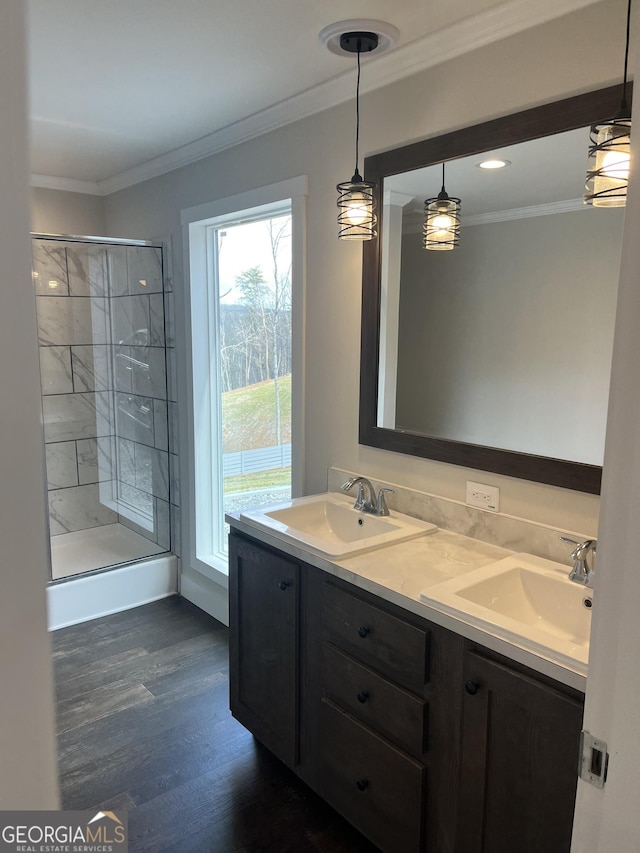 bathroom featuring ornamental molding, hardwood / wood-style floors, vanity, and a shower with shower door