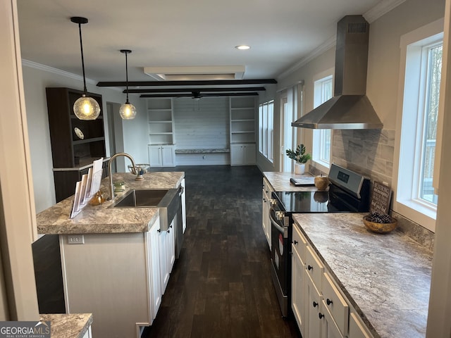 kitchen featuring pendant lighting, wall chimney range hood, stainless steel electric stove, a kitchen island with sink, and white cabinets