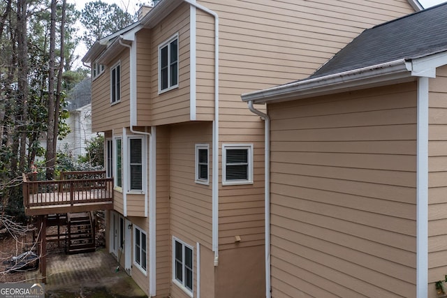 view of home's exterior featuring a deck and a shingled roof