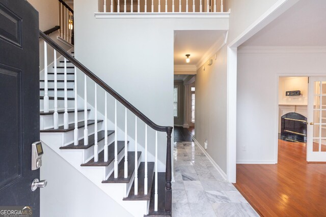 stairs featuring ornamental molding and wood-type flooring