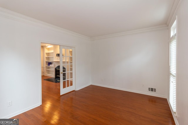 empty room with visible vents, baseboards, ornamental molding, french doors, and wood-type flooring